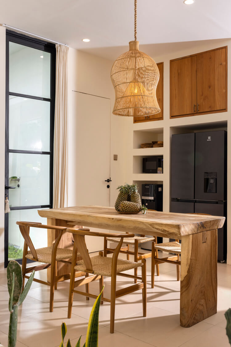 Boho Esszimmer mit langem Holztisch, geflochtenen Stühlen und offenem Regal