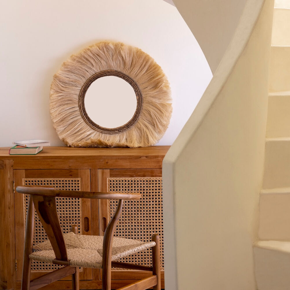 Boho Stuhl Alara steht vor einer Rattan Kommode und einem Spiegel aus Seegras