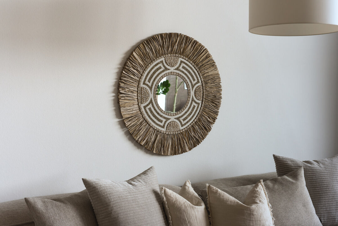 Rattan Spiegel über der Couch im Boho Wohnzimmer