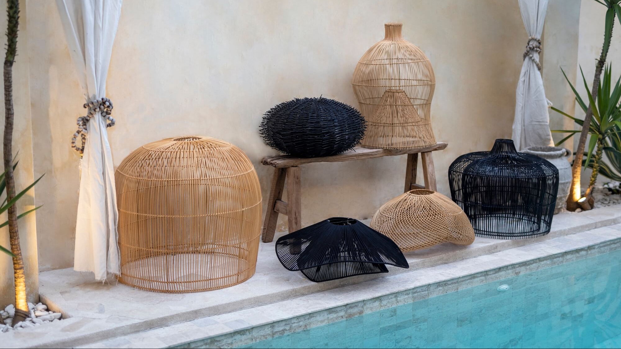 Verschiedene Rattan Lampenschirme liegen neben einem Pool 
