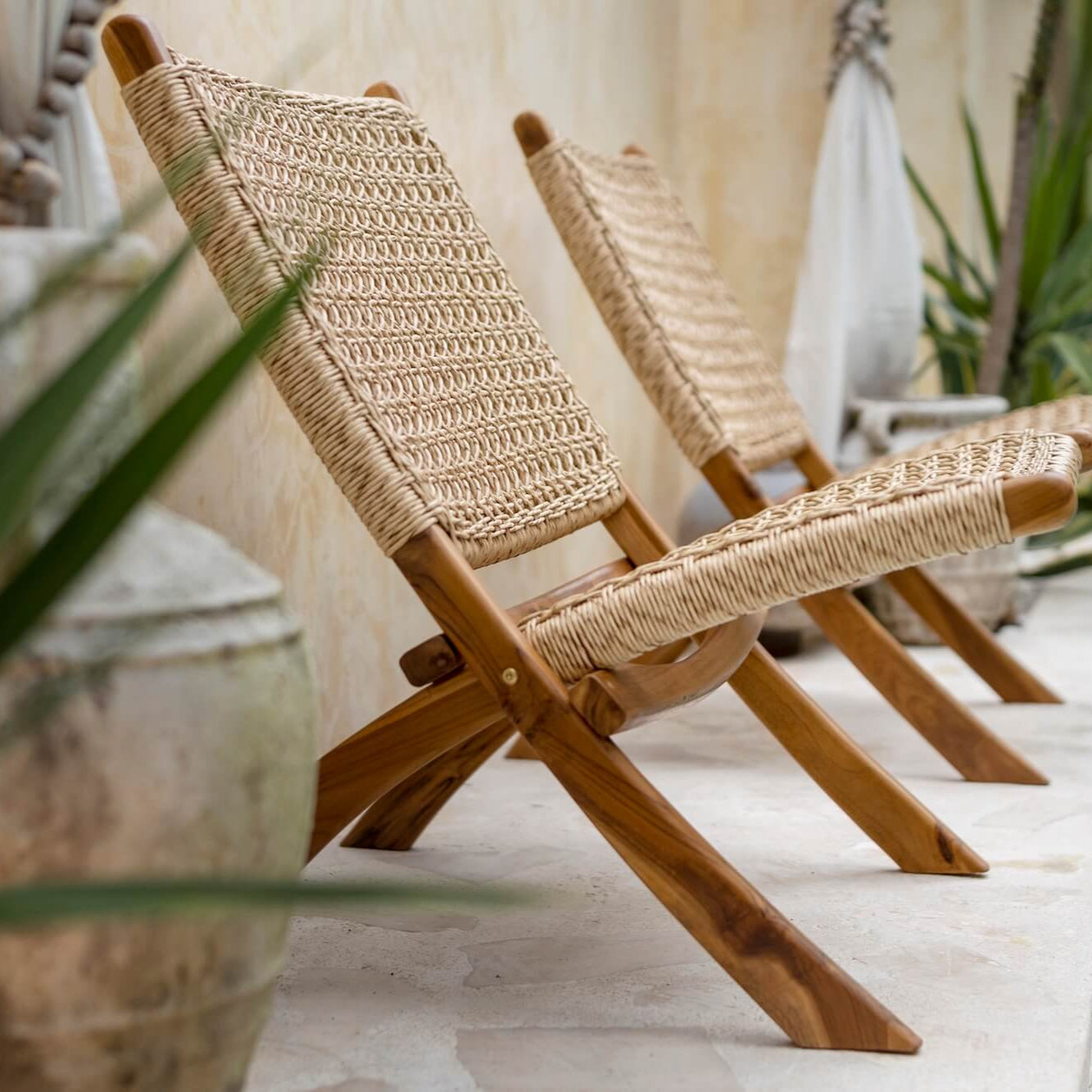 Zwei Rattansessel aus Teakholz am Pool