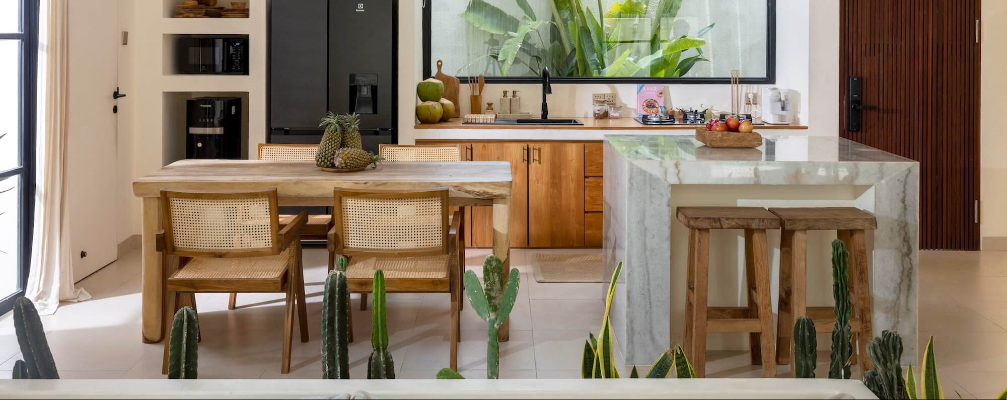 Küche mit offenem Esszimmer im Boho Stil mit Esstisch aus Holz und Rattan Esszimmerstühlen
