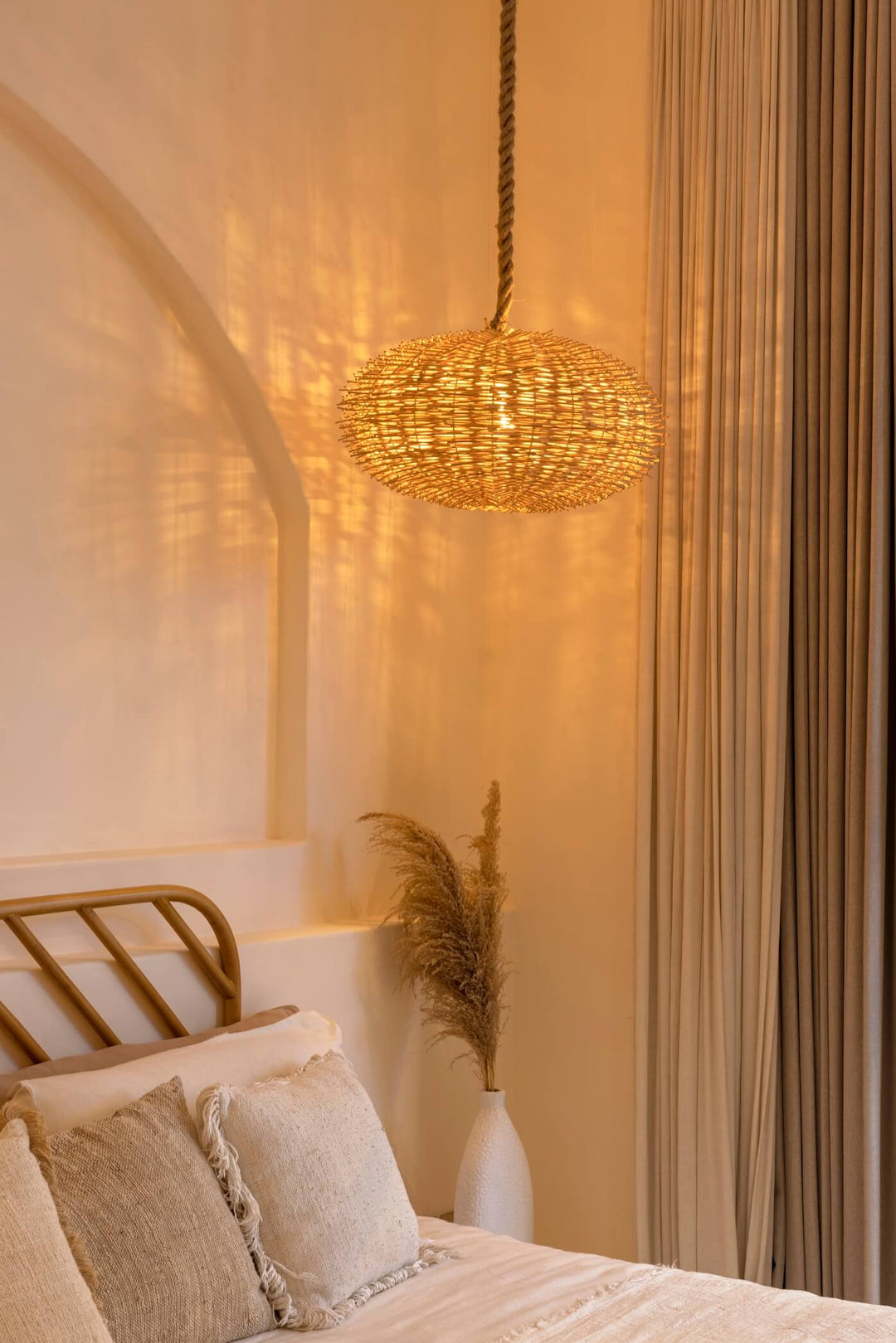 Zenko Rattan Lampe über einem Bett im Schlafzimmer hängend